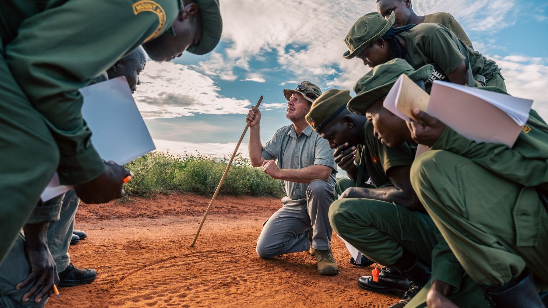 Instruction sur le terrain : des rangers étudient des traces avec un instructeur.